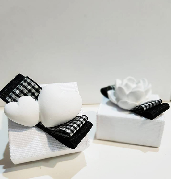 Scatolina portaconfetti in pvc con fascetta in tessuto con decoro in gesso in due soggetti assortiti profumati nozze